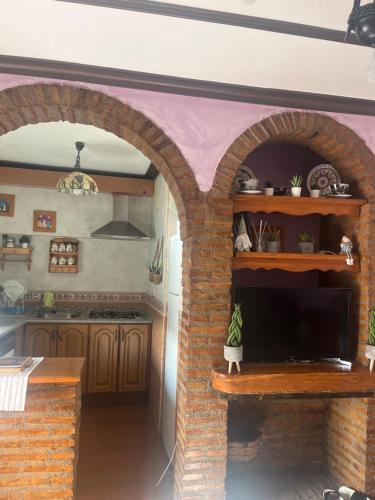 eine Küche mit einem Torbogen und einem gemauerten Kamin in der Unterkunft Retiro del emperador in Cuacos de Yuste