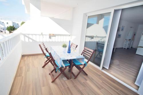 a table and two chairs on a balcony at The 9 souls - pool view in Costa Teguise