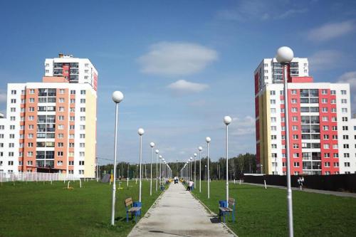 two tall buildings with street lights in a park at Apartment Na Ryabinina in Yekaterinburg