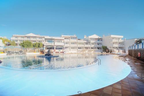 a large swimming pool in front of some buildings at The 9 souls - pool view in Costa Teguise