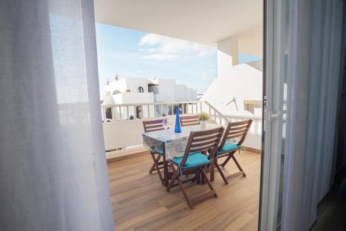 a table and chairs on the balcony of a house at The 9 souls - pool view in Costa Teguise