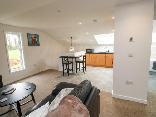 a living room with a couch and a table at Springwell Lodge in Exeter
