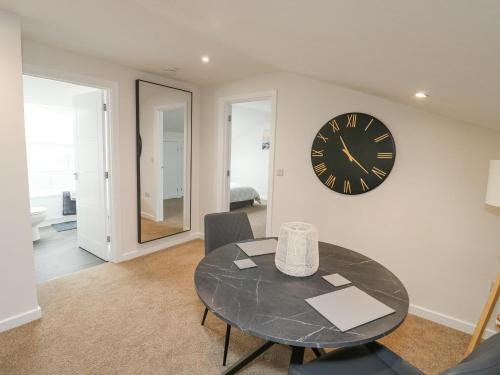 a dining room with a table and a clock on the wall at Springwell Lodge in Exeter