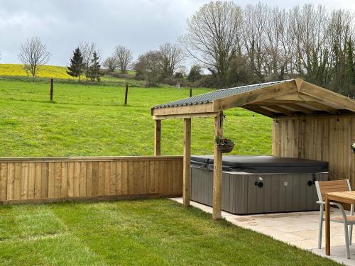 a gazebo with a hot tub in a field at Springwell Lodge in Exeter