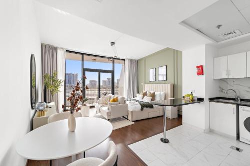 a kitchen and living room with a table and a couch at Silkhaus Vacation Homes Chic Luxury Studio Opposite Silicon Oasis Shopping Mall in Dubai