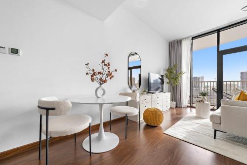 a white living room with a table and chairs at Silkhaus Vacation Homes Chic Luxury Studio Opposite Silicon Oasis Shopping Mall in Dubai