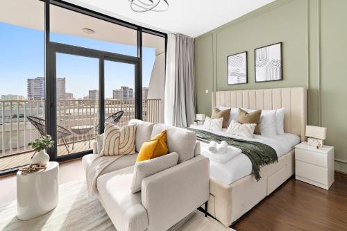 a bedroom with a white bed and a couch at Silkhaus Vacation Homes Chic Luxury Studio Opposite Silicon Oasis Shopping Mall in Dubai