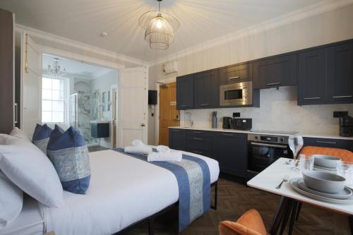 a bedroom with a large bed and a kitchen at Imperial York Street Apartments in London