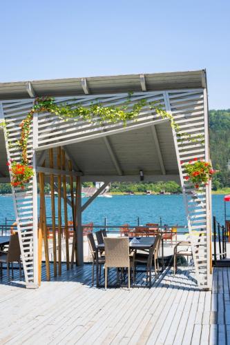 a patio with tables and chairs on a dock at Hotel Pescarus Port Bicaz in Bicaz