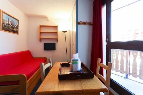 a living room with a table and a red couch at Plein Sud - 2301 - Studio pied des pistes - 2 pers in Les Deux Alpes