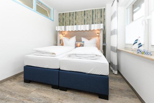 a bedroom with a blue and white bed in a room at Haus Strandkorb mit Frühstücksoption in Bensersiel