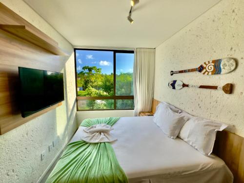 Schlafzimmer mit einem Bett, einem TV und einem Fenster in der Unterkunft Villa Cotinguiba in Pôrto de Pedras