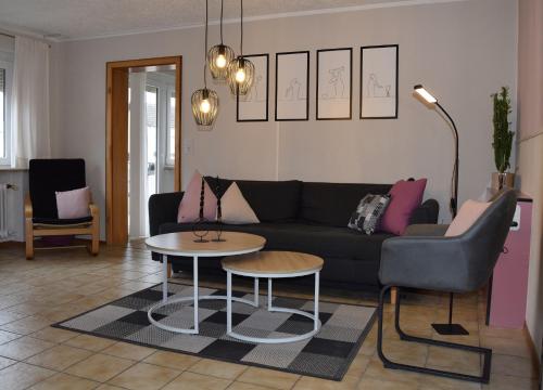 a living room with a black couch and a table at Ferienwohnung auf dem Dorf, Külsheim in Külsheim