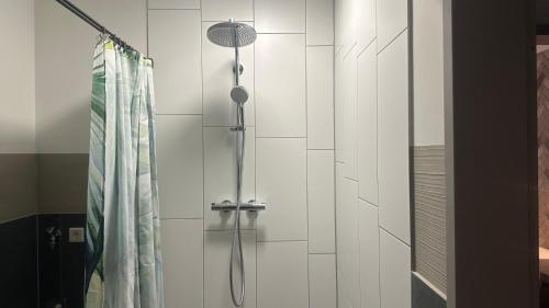 een douche met een douchekop in de badkamer bij Hotel Garni FairSchlafen in Minden