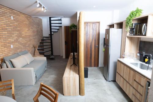 eine Küche und ein Wohnzimmer mit einer Couch und einem Kühlschrank in der Unterkunft Villa Cotinguiba in Pôrto de Pedras