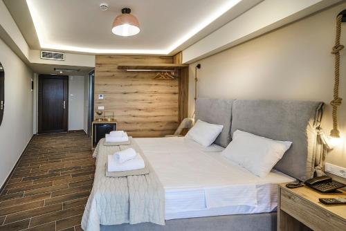 a bedroom with a large white bed and a desk at Anthidon Nature Estate & Farm in Chalkida