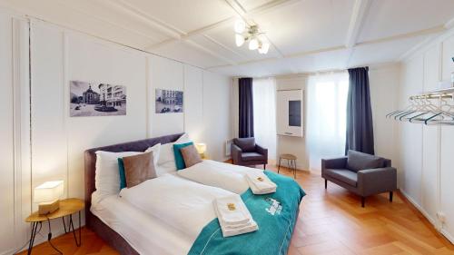 ein Wohnzimmer mit einem Bett und einem Stuhl in der Unterkunft Zentrale 2,5 Altstadtwohnung - Boxspringbett - Smart TV in Chur