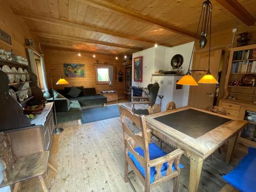 Sertig Döfli的住宿－Zauberberg in voller Pracht，厨房以及带木桌和椅子的客厅。