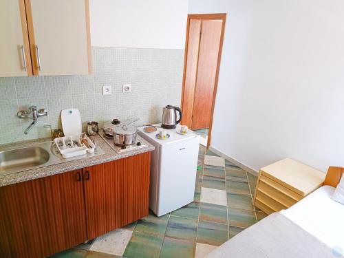 uma pequena cozinha com um lavatório e um frigorífico em Amisos Boutique Hotel em Bečići