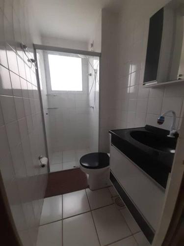 ein Bad mit einem schwarzen WC und einem Waschbecken in der Unterkunft Cantinho Andorinhas in Campinas
