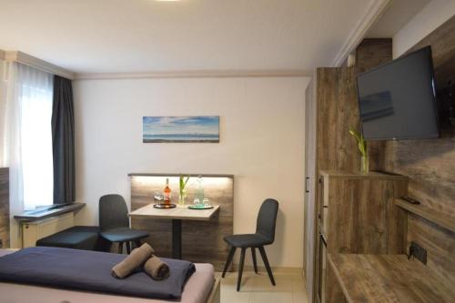 a bedroom with a bed and a table with chairs at Hotel Zum Bengel in Meersburg