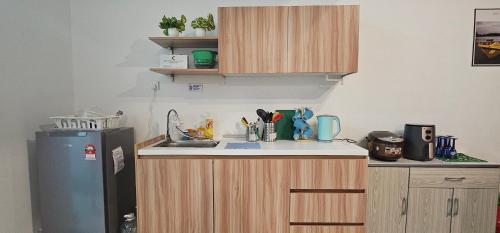 a kitchen with wooden cabinets and a refrigerator at Empire City M Tower in Petaling Jaya