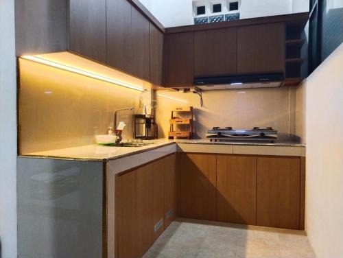 a kitchen with wooden cabinets and a stove at Griya Delvin in Temon