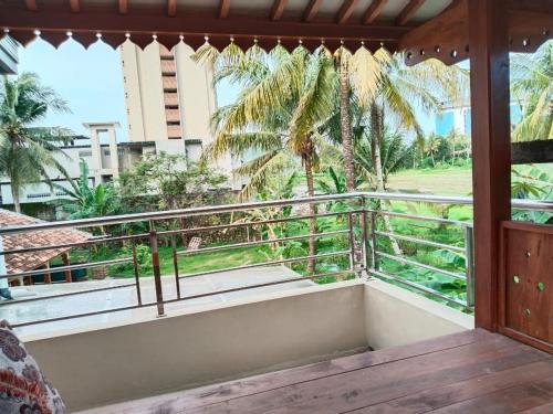 a balcony with a view of the palm trees at Griya Delvin in Temon