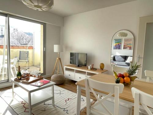 a living room with a table and a television at .L'Armor. Appartement avec terrasse & parking in Les Sables-d'Olonne
