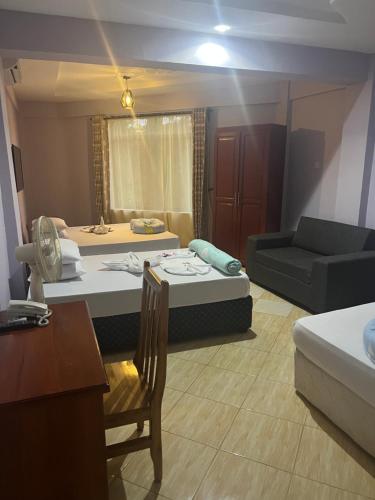 uma sala de estar com duas camas e um sofá em luxpalacehotel limited em Moshi