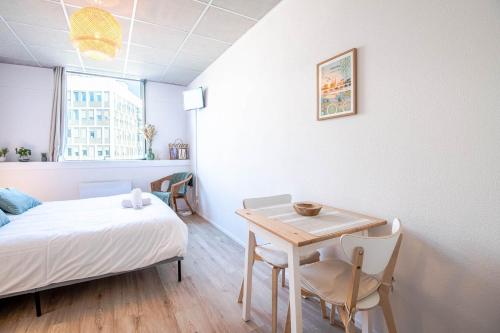 une chambre avec un lit, une table et des chaises dans l'établissement Appartement Le Cocooning, à Tours