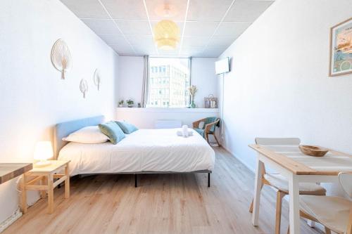 une chambre blanche avec un lit et une table dans l'établissement Appartement Le Cocooning, à Tours