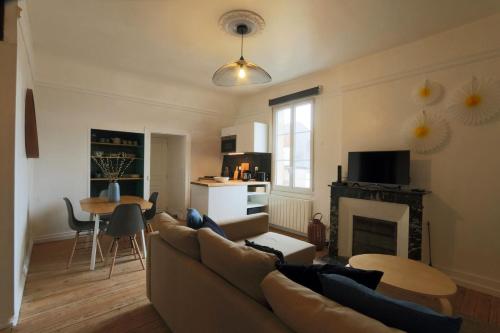 un salon avec un canapé et une cheminée dans l'établissement Let's take a walk in the woods, à Tours