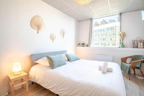 une chambre avec un lit blanc et une fenêtre dans l'établissement Appartement Le Cocooning, à Tours