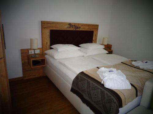 a bedroom with two beds with white sheets and towels at Familienhotel Berger in Sankt Jakob im Walde