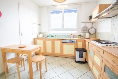 - une cuisine avec des placards en bois, une table et un évier dans l'établissement Le Botanique - Joli appart à Tours, à Tours