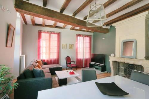 ein Wohnzimmer mit einem Sofa und einem Kamin in der Unterkunft Exceptional location L'Hôtel des Gouverneurs in Chinon