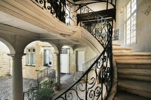 a staircase in a building with a wrought iron railing at Exceptional location L'Hôtel des Gouverneurs in Chinon