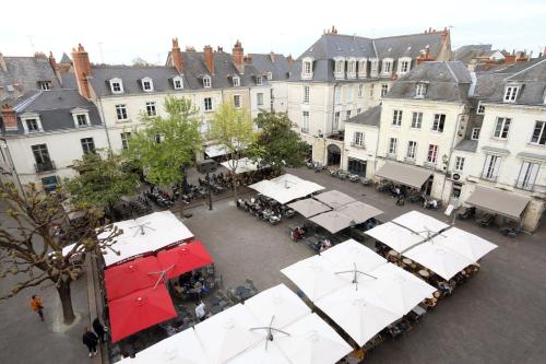 een uitzicht op een straat met tafels en witte parasols bij Charmant Studio authentique#Tours#PlacePlumereau in Tours