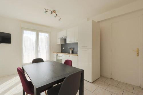 una cucina e una sala da pranzo con tavolo e sedie di La Chanterie a Saint-Cyr-sur-Loire