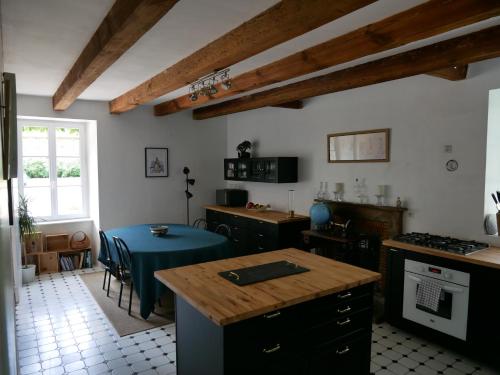 Miniac-MorvanにあるGîtes de Launay Guibertのキッチン(テーブル、青いテーブルクロス付)