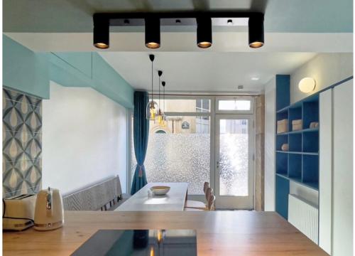 una cocina con una gran mesa de madera y paredes azules en Appartement Atypique Au Pied Du Sacré Cœur, en París