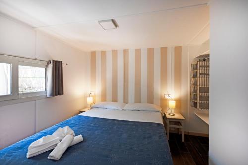 a bedroom with a bed with two white towels on it at Camping Villaggio Nettuno in Nerano