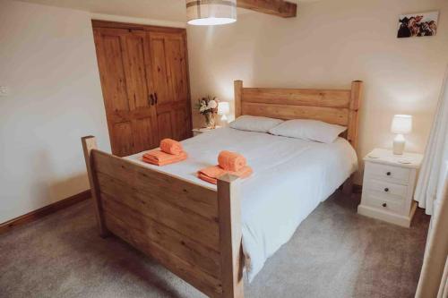 a bedroom with a large bed with two towels on it at Mabels Cottage, Longnor in Longnor