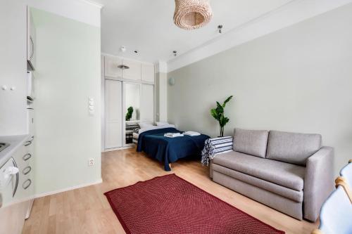 a living room with a couch and a bed at Centrum - Lovely furnished Studio in Helsinki