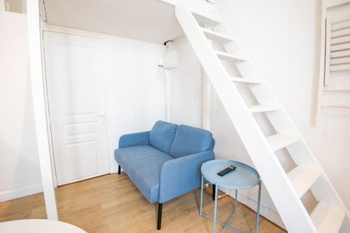 une chaise bleue dans une pièce avec une échelle dans l'établissement Little Victor Hugo, à Tours