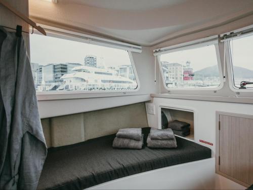 um pequeno quarto com duas almofadas num barco em Waterfront Houseboat em Cidade do Cabo