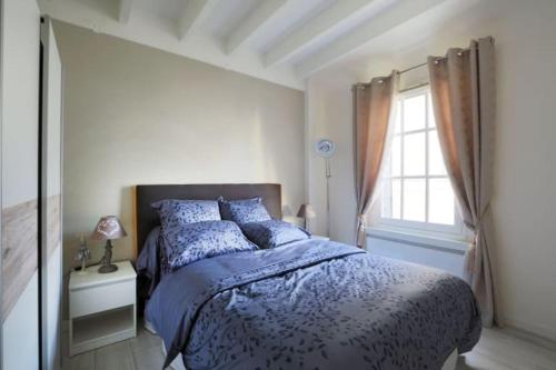 una camera da letto con un letto con un piumone blu e una finestra di Charming T3 Tours hypercentre a Tours