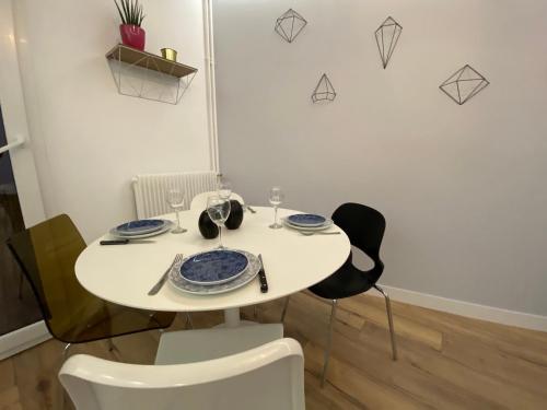 une table blanche avec deux chaises et une plaque de cuisson dans l'établissement Lumineux T2 situé dans l'hyper centre de Tours, à Tours