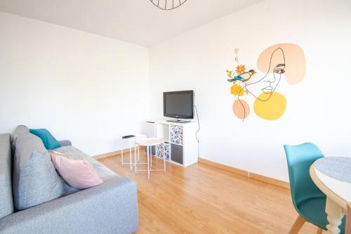 un salon avec un canapé et une télévision dans l'établissement Pastel colors - Tours, à Tours